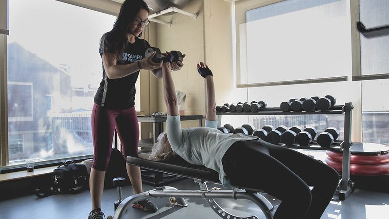 personal trainer works with patron