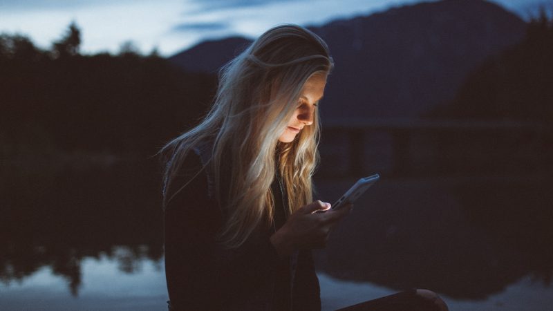 Woman looks at phone at night