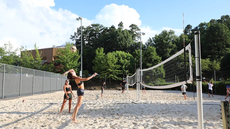 students play sand volleyball