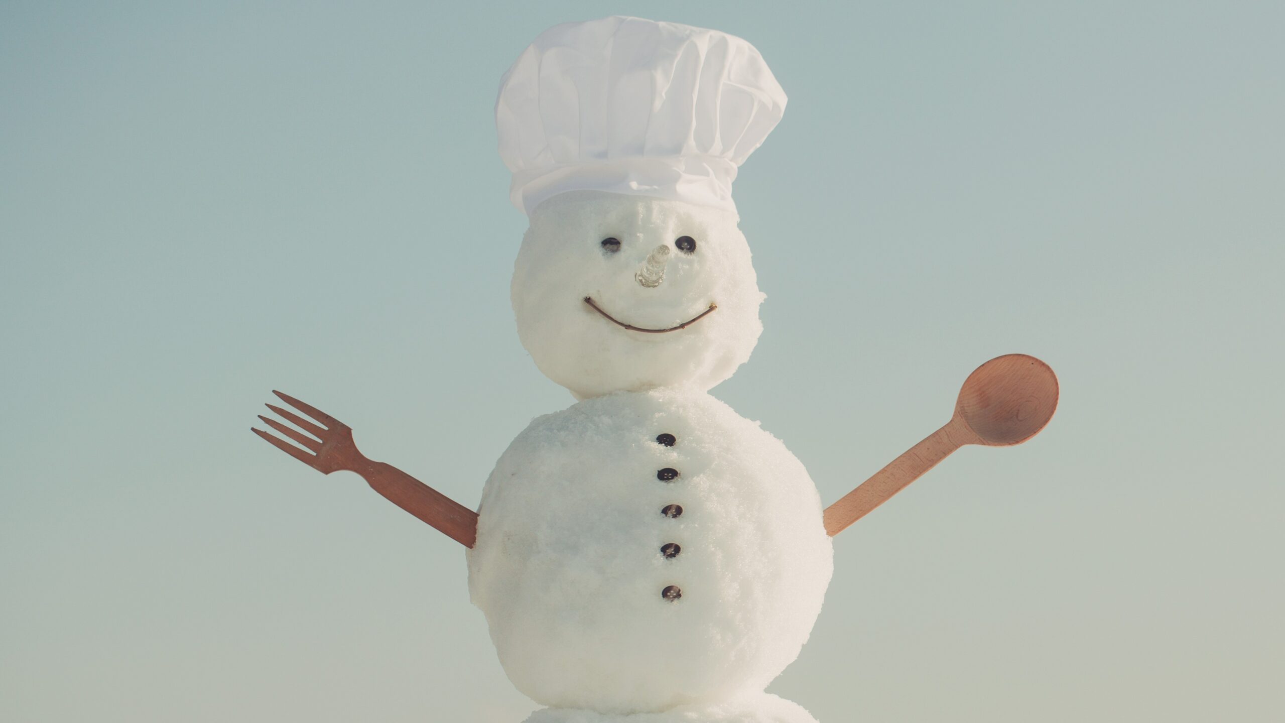 Snowman with a chef's hat and one fork and one spoon for arms